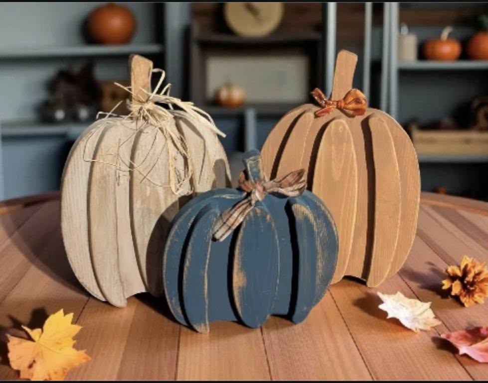 Country Blue and Aztec Orange ribbed wood pumpkins with raffia and ribbon ties on a windowsill