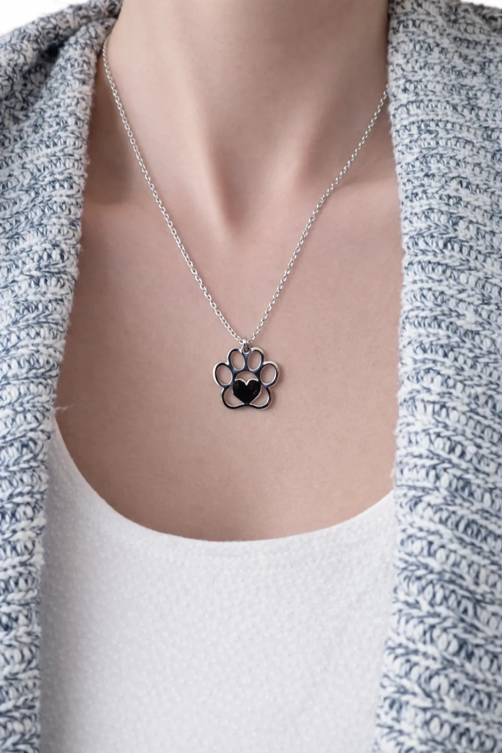 Woman wearing a silver paw print pendant necklace