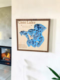 Custom Cass Lake wooden depth map hanging by a fireplace