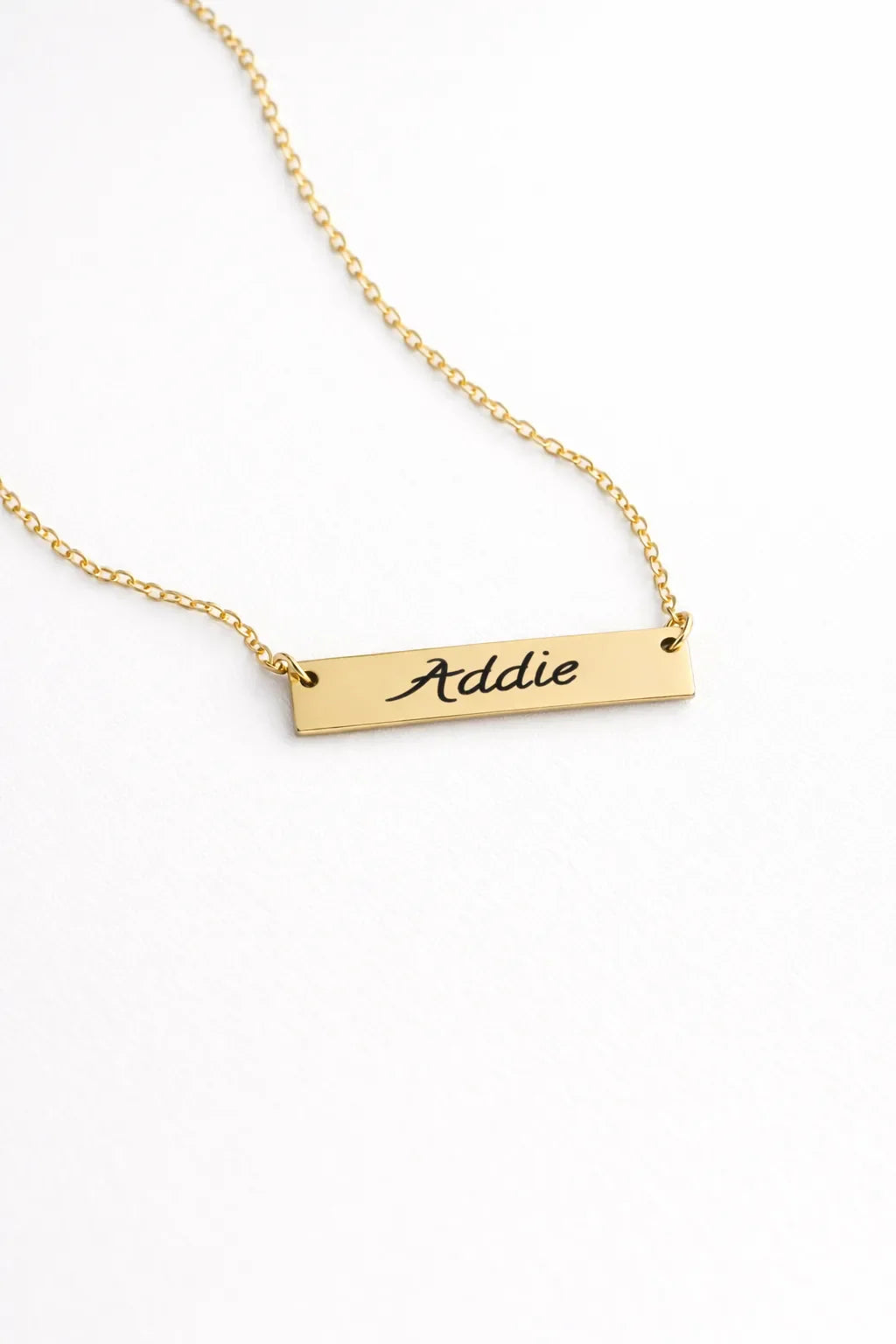 Gold horizontal bar necklace engraved with the name Addie